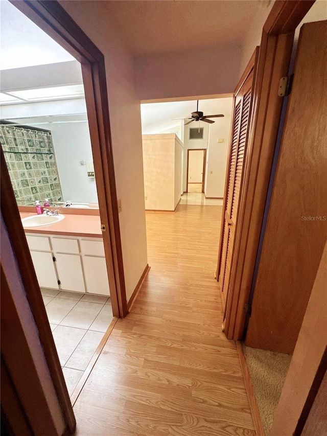 hall with sink and light hardwood / wood-style floors