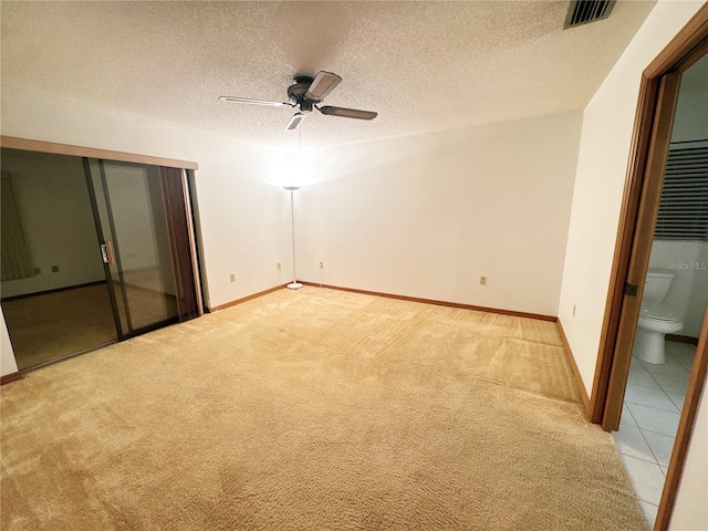 carpeted empty room with ceiling fan and a textured ceiling