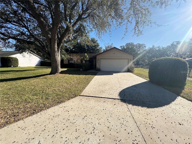 ranch-style house featuring a garage and a front lawn