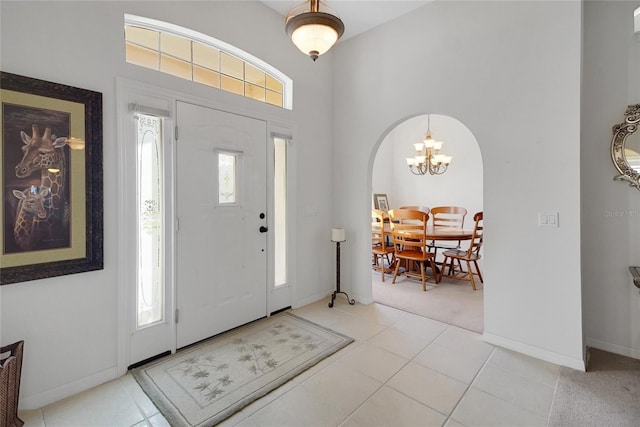 tiled entryway with a chandelier and a wealth of natural light