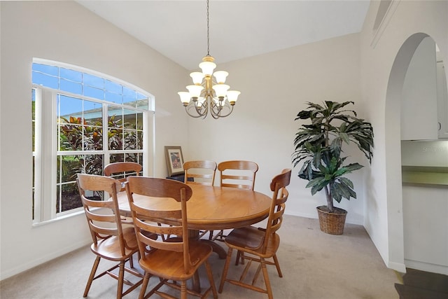 dining room featuring light carpet and a notable chandelier