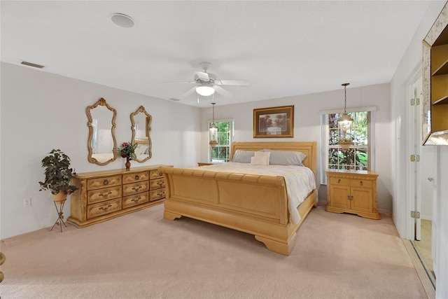 carpeted bedroom with multiple windows and ceiling fan