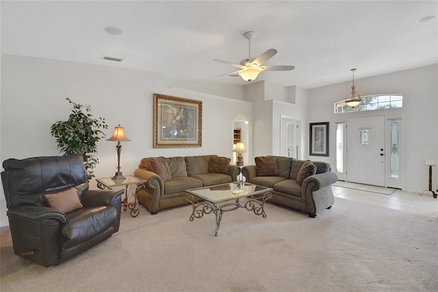 living room featuring light carpet, a towering ceiling, and ceiling fan