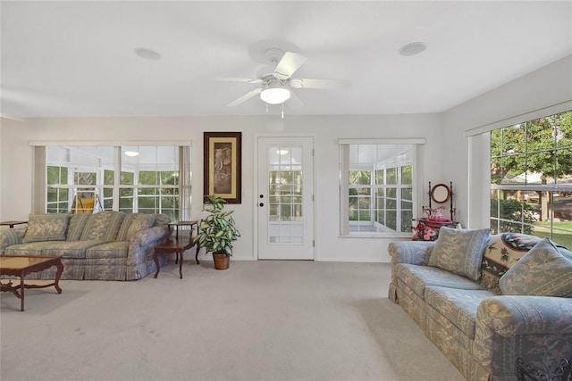 living room featuring ceiling fan, plenty of natural light, and light carpet