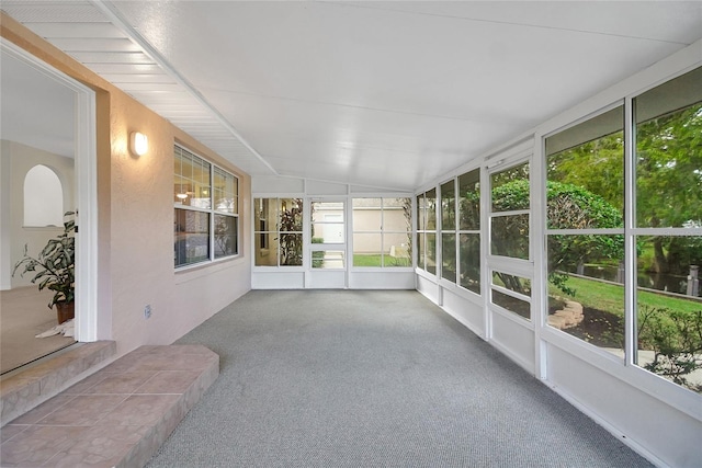 unfurnished sunroom featuring vaulted ceiling