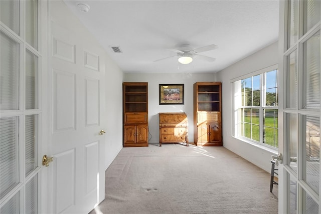 interior space featuring ceiling fan, light colored carpet, and french doors