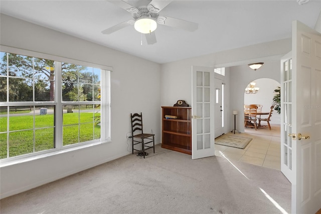 interior space featuring light carpet, french doors, a wealth of natural light, and ceiling fan