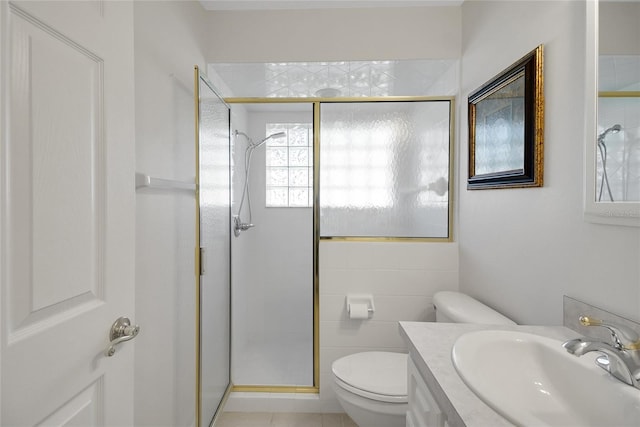 bathroom featuring tile patterned floors, an enclosed shower, vanity, tile walls, and toilet