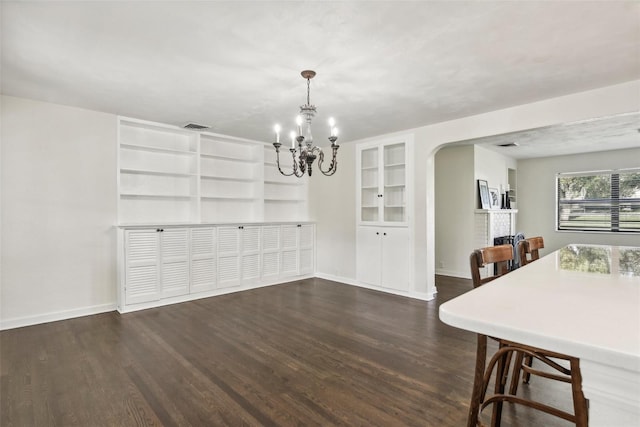 unfurnished dining area featuring dark wood-type flooring and a chandelier