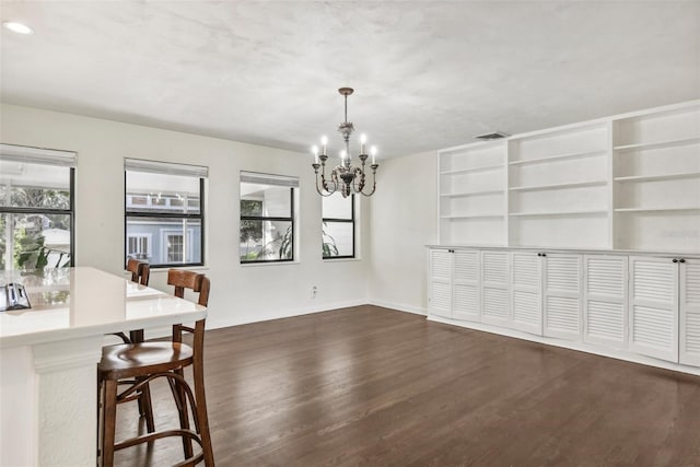 dining area with an inviting chandelier and dark wood-type flooring