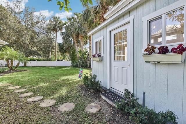 view of exterior entry featuring a yard