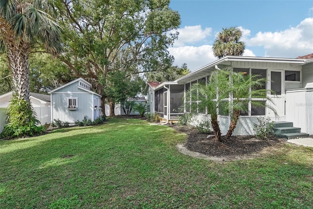 view of yard featuring a sunroom and a storage unit