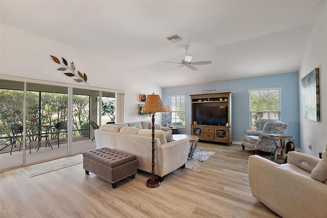 living room featuring ceiling fan, light hardwood / wood-style floors, and lofted ceiling