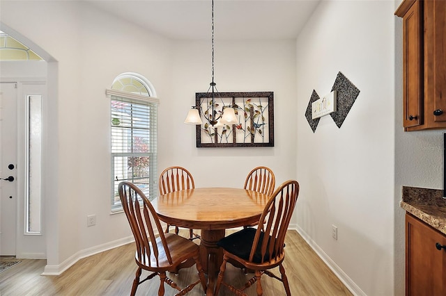 dining room with light hardwood / wood-style floors and a notable chandelier