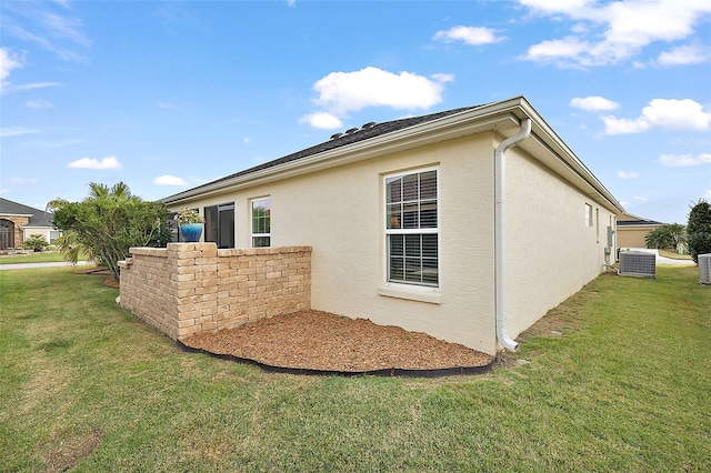 view of side of home featuring a yard and central air condition unit