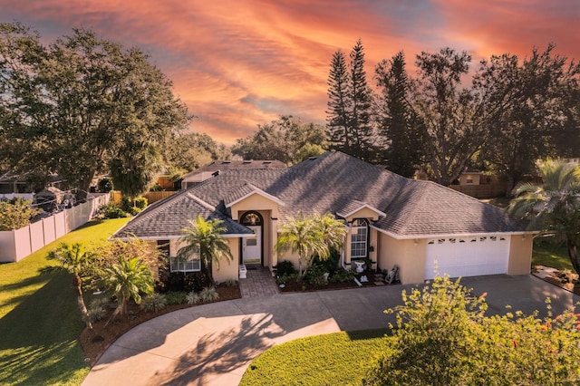 ranch-style house featuring a lawn and a garage