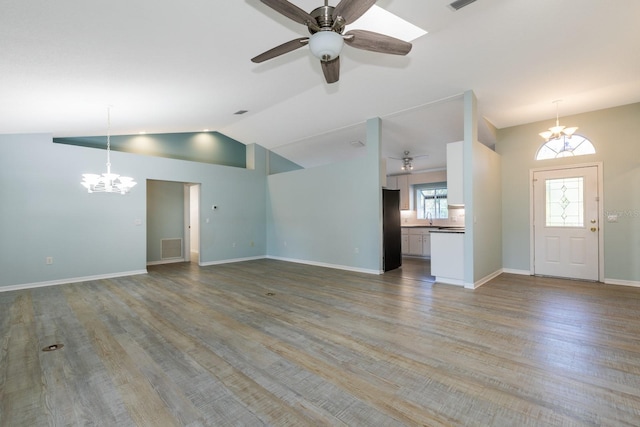 unfurnished living room featuring hardwood / wood-style floors, ceiling fan with notable chandelier, lofted ceiling, and sink