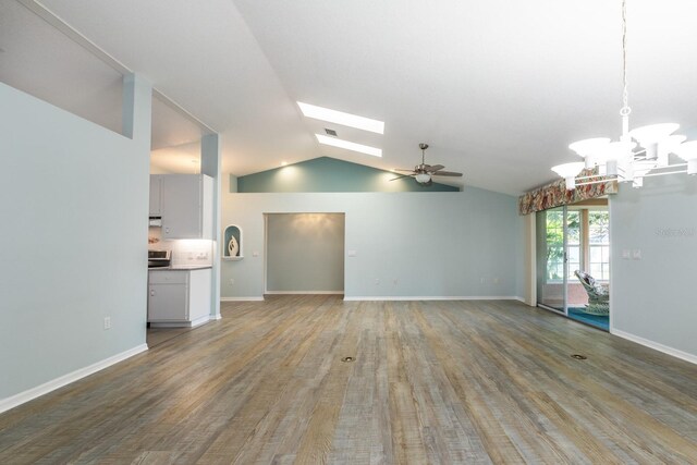 unfurnished living room featuring ceiling fan with notable chandelier, hardwood / wood-style flooring, and lofted ceiling with skylight