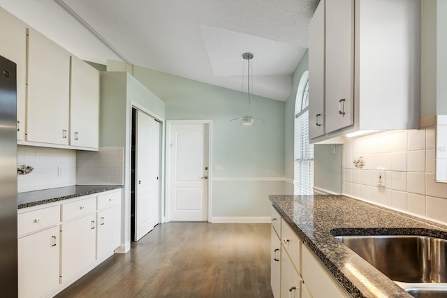 kitchen featuring white cabinets, decorative light fixtures, dark hardwood / wood-style floors, and lofted ceiling