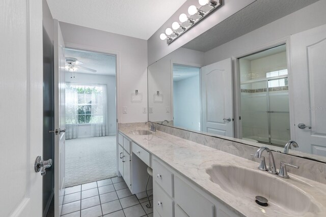 bathroom with ceiling fan, tile patterned flooring, an enclosed shower, a textured ceiling, and vanity