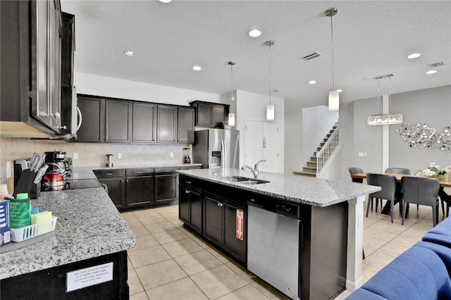 kitchen with a kitchen island with sink, hanging light fixtures, and appliances with stainless steel finishes