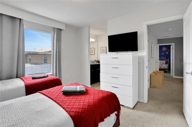 carpeted bedroom featuring ensuite bath