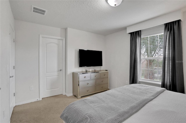 carpeted bedroom featuring a textured ceiling