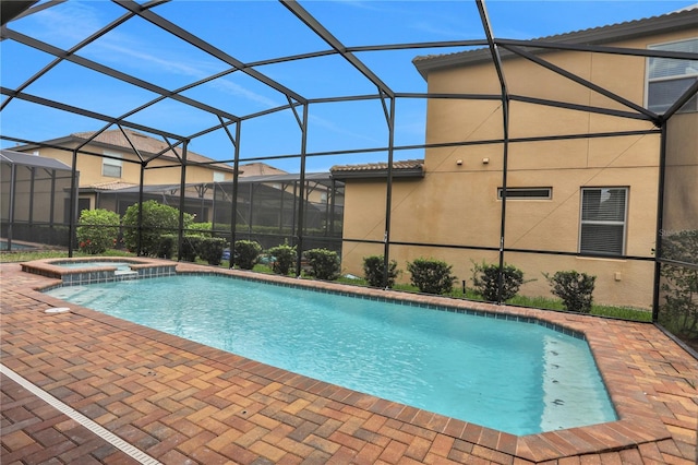 view of swimming pool with a patio area, a lanai, and an in ground hot tub