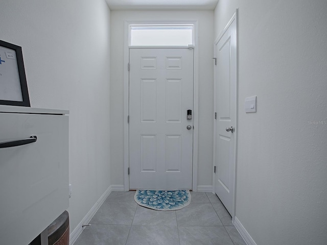 doorway to outside with light tile patterned floors