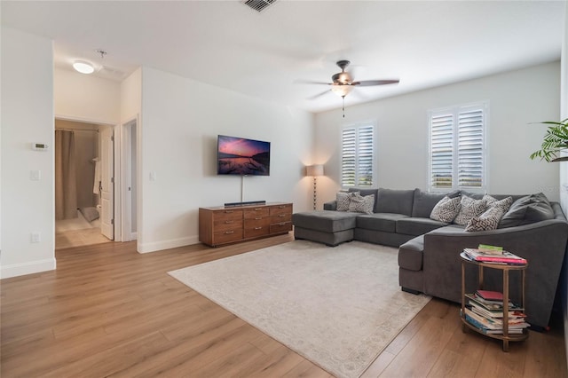 living room with ceiling fan and light hardwood / wood-style flooring