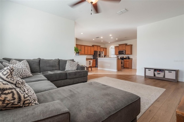 living room featuring ceiling fan and light wood-type flooring