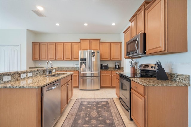 kitchen featuring stainless steel appliances, light stone countertops, light tile patterned flooring, and sink