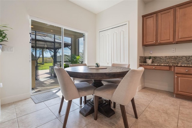 dining space with built in desk and light tile patterned floors