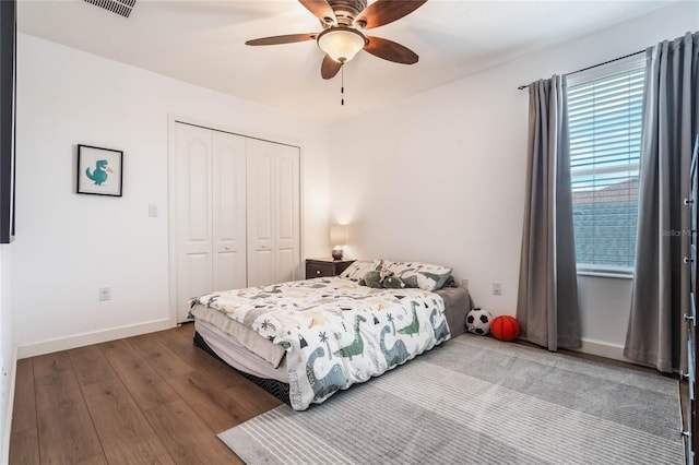 bedroom with wood-type flooring, ceiling fan, and a closet