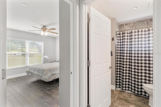 bedroom with ceiling fan, light hardwood / wood-style floors, and a textured ceiling