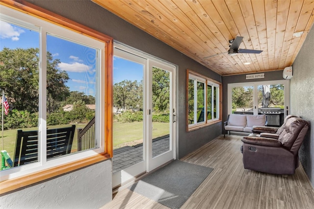 sunroom featuring a wall mounted air conditioner, french doors, ceiling fan, and wooden ceiling