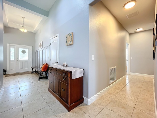 tiled entryway featuring a tray ceiling