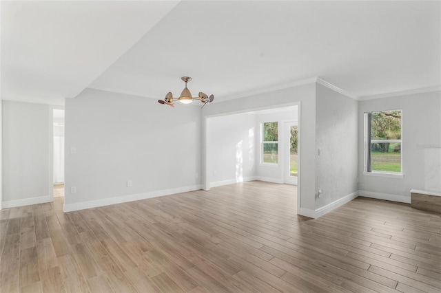 unfurnished living room featuring light hardwood / wood-style flooring, ornamental molding, and a notable chandelier