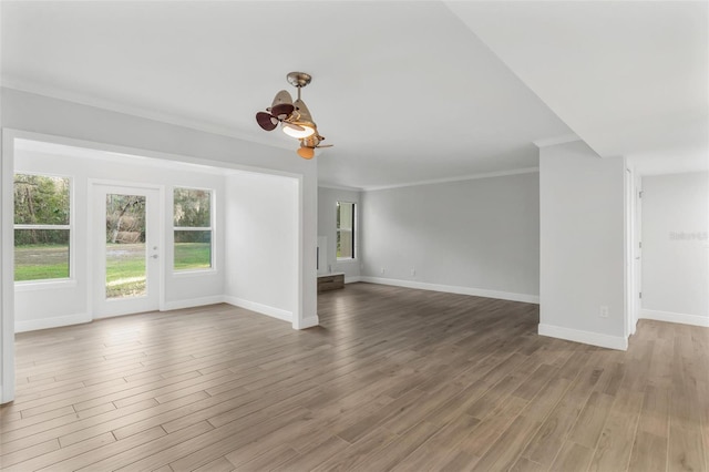 unfurnished living room with hardwood / wood-style flooring and crown molding