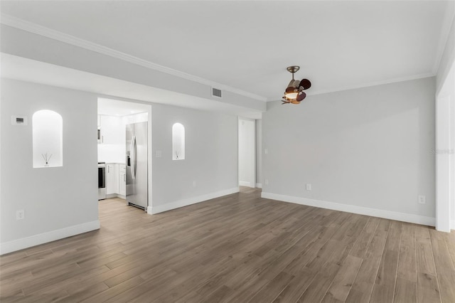 empty room with crown molding and light hardwood / wood-style flooring