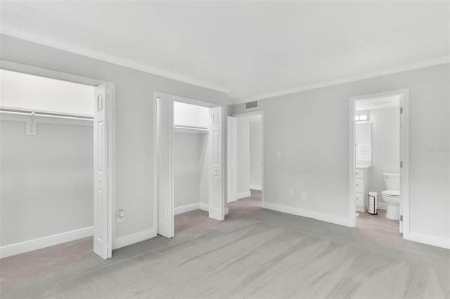 unfurnished bedroom with connected bathroom, multiple closets, light colored carpet, and ornamental molding