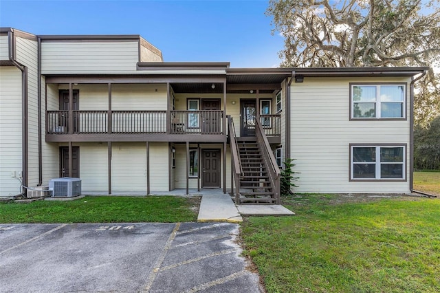 view of front of property featuring a front yard and central AC unit