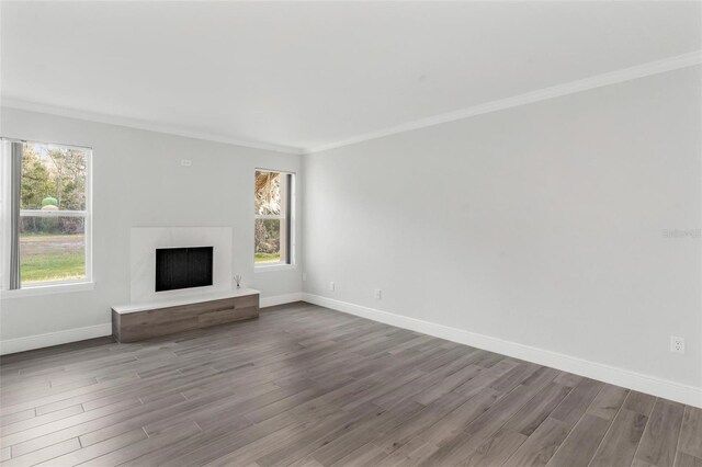 unfurnished living room with crown molding and light hardwood / wood-style floors