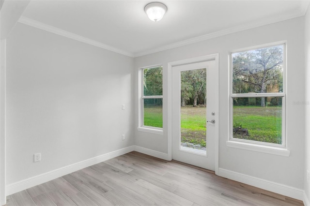 entryway with light hardwood / wood-style floors, crown molding, and a healthy amount of sunlight