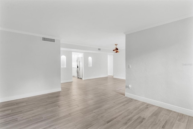 spare room featuring light hardwood / wood-style floors and crown molding