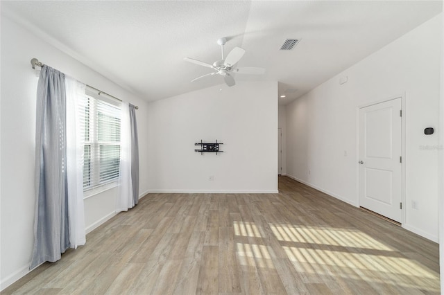 empty room with light wood-type flooring, ceiling fan, and lofted ceiling