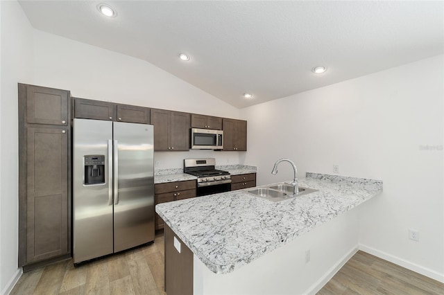 kitchen featuring light hardwood / wood-style floors, kitchen peninsula, sink, and appliances with stainless steel finishes