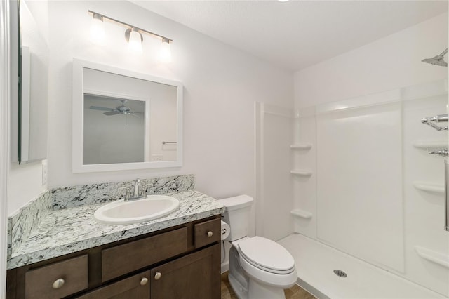 bathroom featuring a shower, vanity, toilet, and ceiling fan