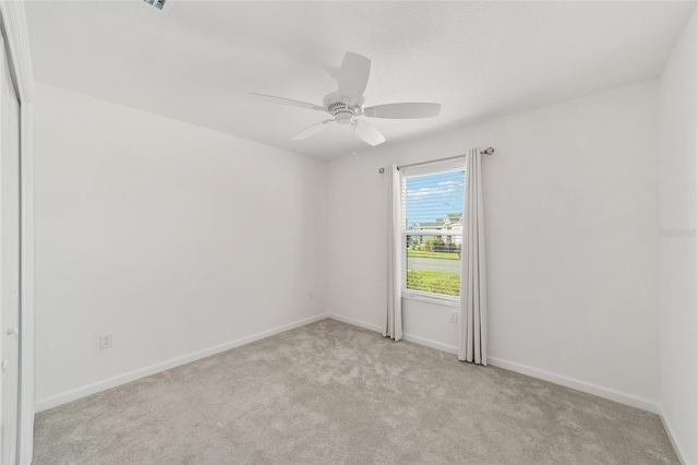 unfurnished room featuring light colored carpet and ceiling fan