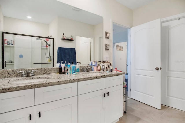 bathroom with vanity, a shower with shower door, and tile patterned flooring